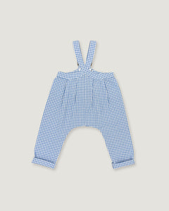 A pair of children's blue and white gingham suspenders with a high waist and wide legs, laid flat on a light beige background.