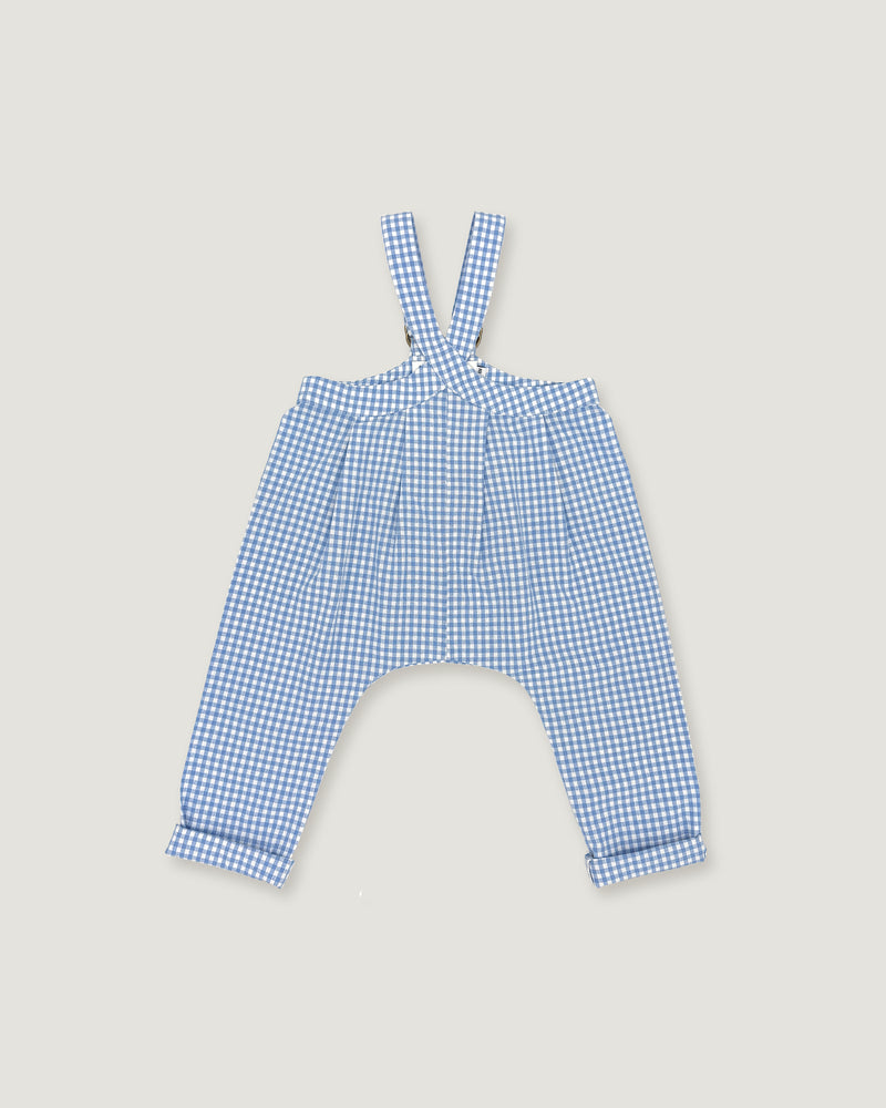 A pair of children's blue and white gingham suspenders with a high waist and wide legs, laid flat on a light beige background.