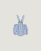 A baby romper with suspenders in a blue and white gingham check pattern, featuring adjustable shoulder straps with metal rings, laid flat on a light beige background.
