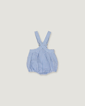 A baby romper with blue and white gingham check pattern and adjustable shoulder straps, shown flat on a light beige background.