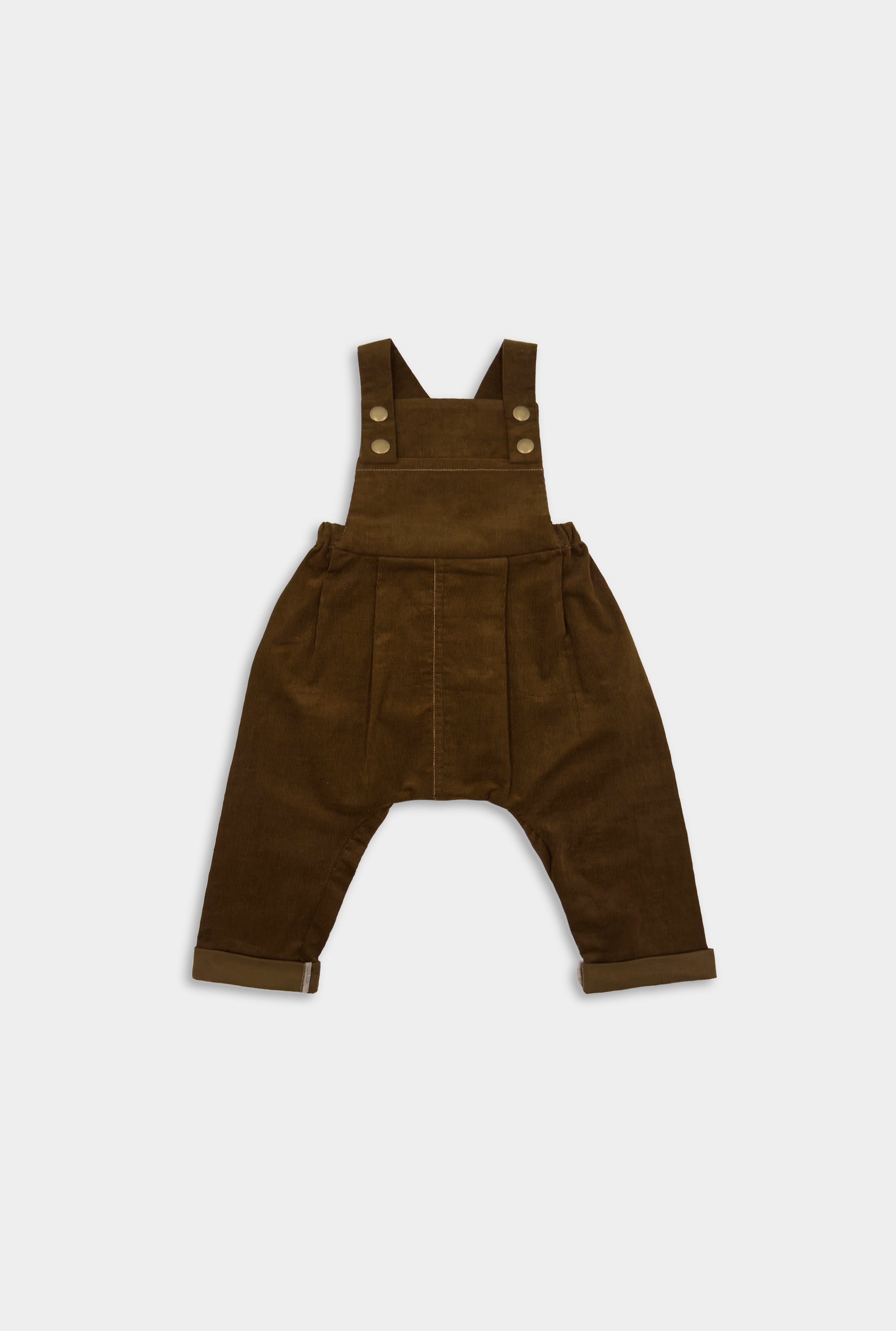 Front view of cozy handmade cocoa brown long overalls, showcasing the spacious bib pocket and stylish pleats, designed for comfort and adventure in children’s wear.Front view of cozy cocoa brown long overalls, showcasing the spacious bib pocket and stylish pleats, designed for comfort and adventure in children’s wear.