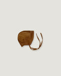A brown corduroy bonnet with adjustable tie straps, photographed flat against a light gray background.