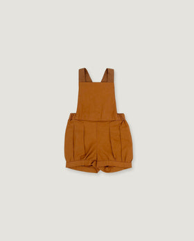 A toddler's short overall romper in a warm camel brown color, laid flat against a light gray background.