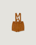 A pair of toddler's pleated shorts in a warm camel brown color, featuring adjustable shoulder straps with a crossed design and a small white brand tag.