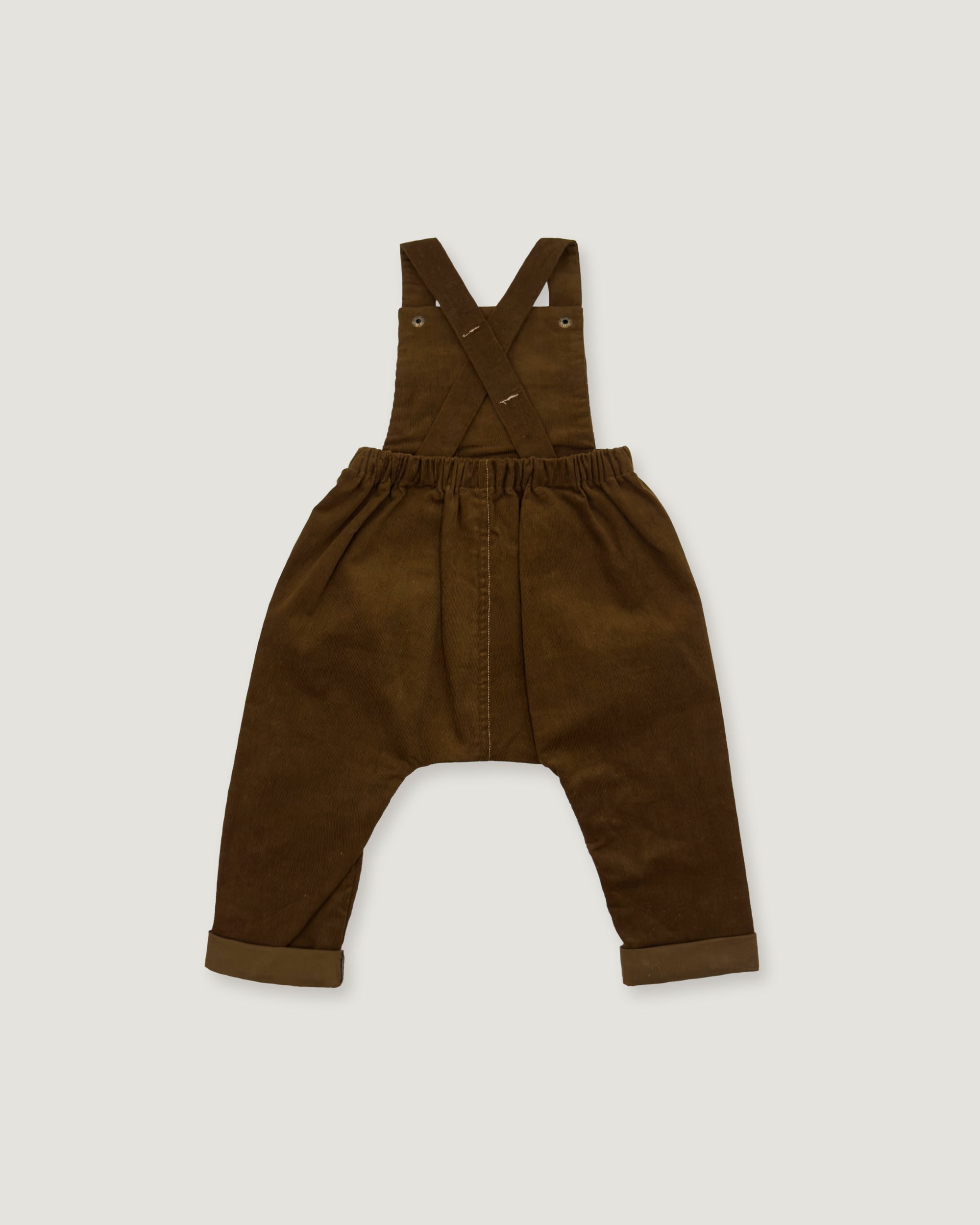 A pair of dark brown corduroy baby overalls with adjustable shoulder straps and a wide elastic waistband, laid flat on a light gray background.