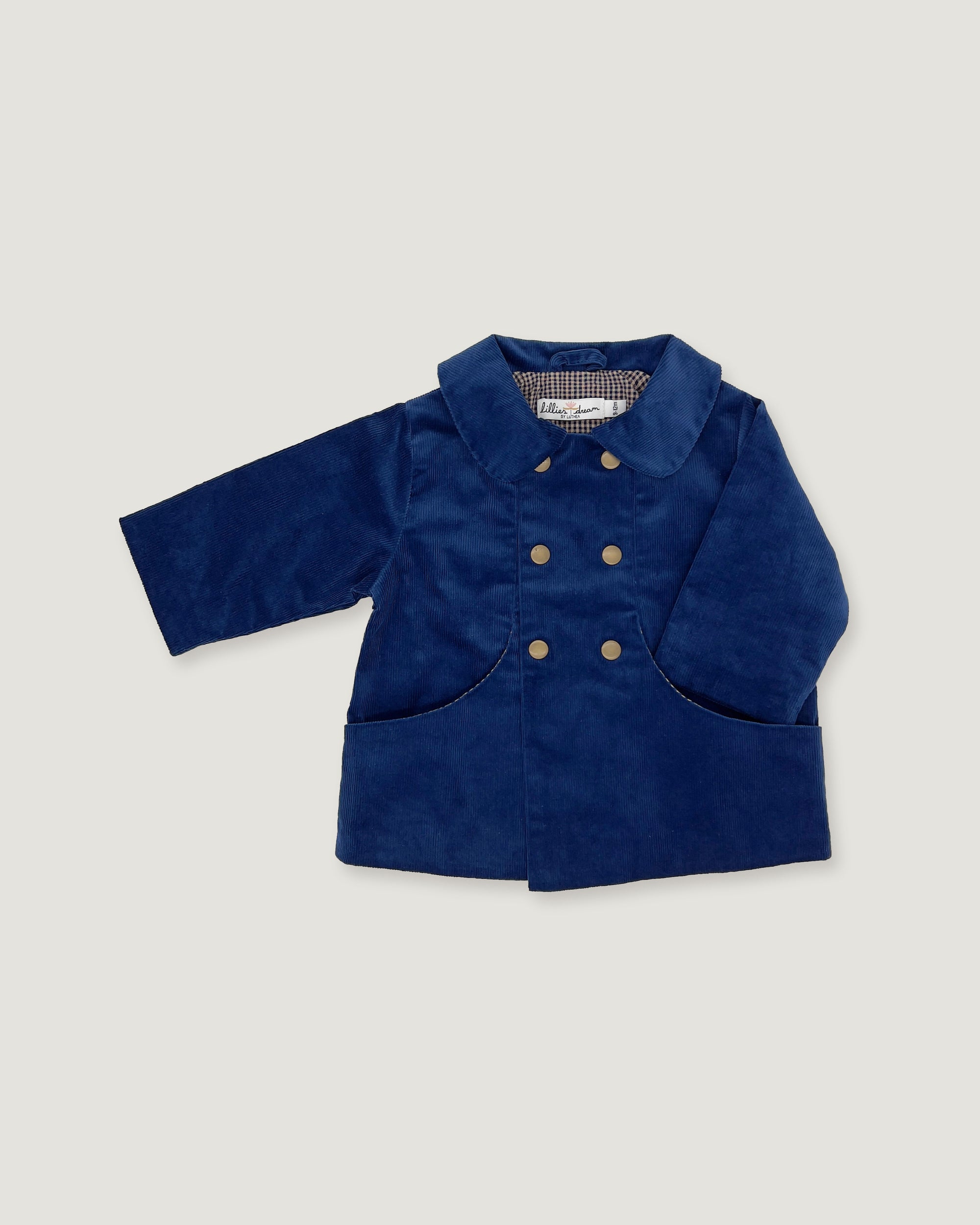A navy blue corduroy jacket for a toddler, featuring a double-breasted design with gold buttons, a pointed collar, and front patch pockets, shown against a light gray background.