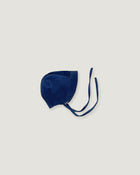 A navy blue corduroy bonnet with long ties, photographed flat on a light gray background.