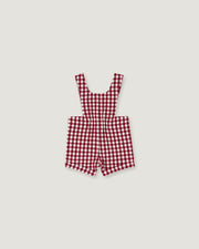 A red and white gingham check baby romper with shoulder straps, laid flat on a light gray background.