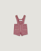 A baby romper in a red and white gingham check pattern, featuring adjustable shoulder straps and front patch pockets, displayed flat against a light gray background.