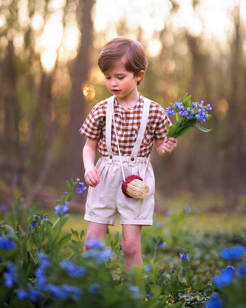 Child holding flowers in a field with a blurred natural background