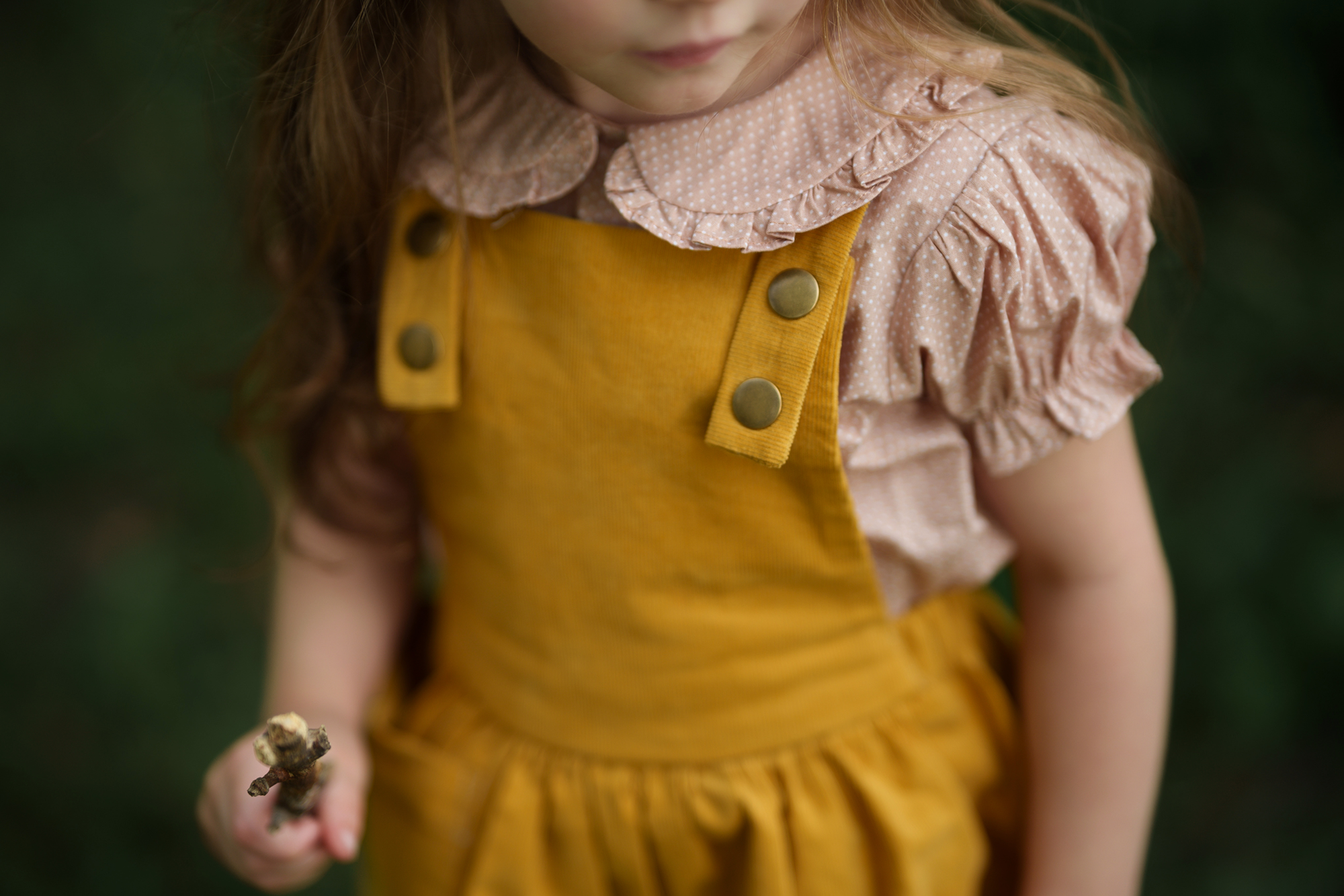 Close-up of the bib detail on the Mustard Pinafore, featuring a generous pocket designed for little treasures, showcasing the quality craftsmanship of our handmade children’s wear.