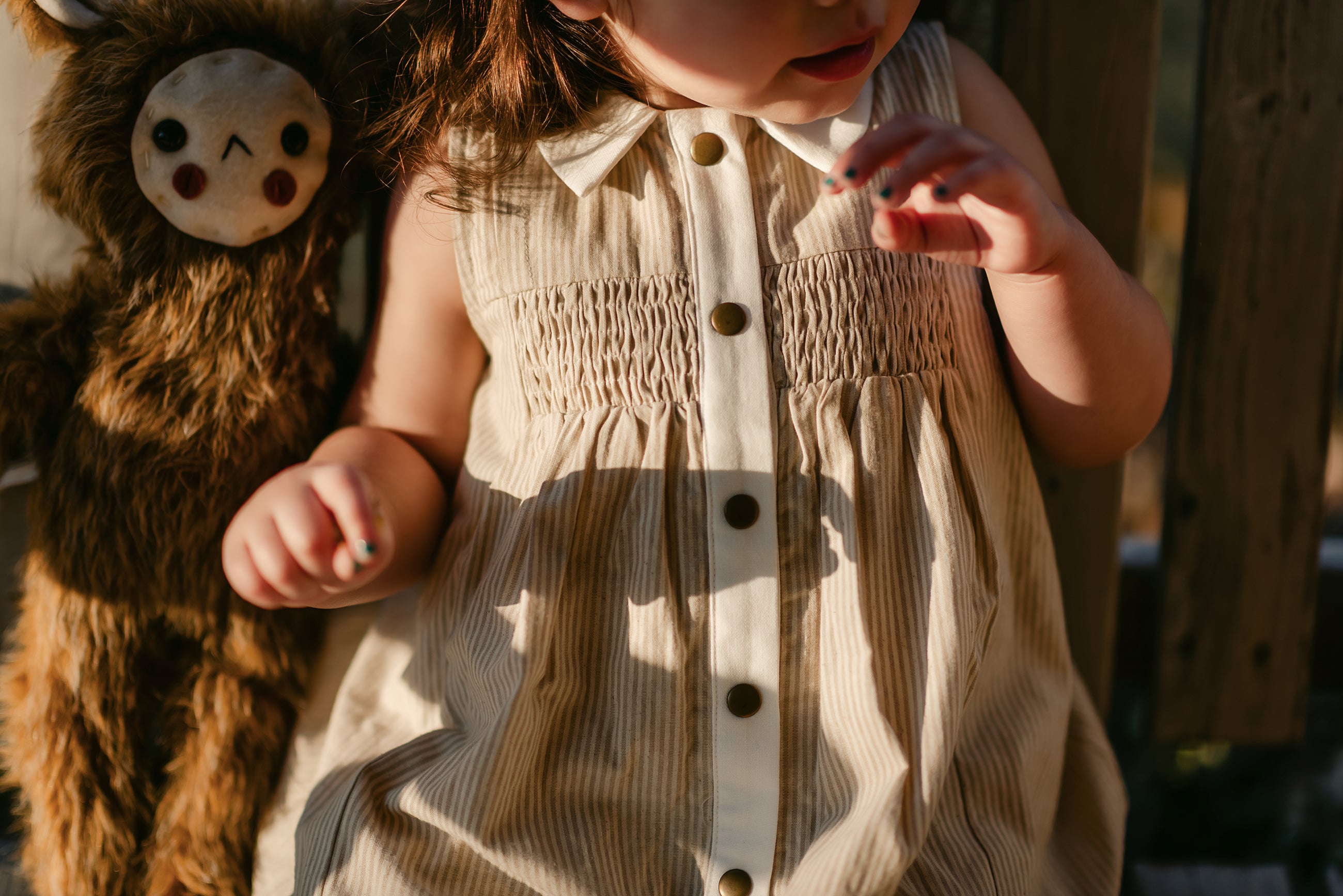 girl in a beige striped dress in the sun