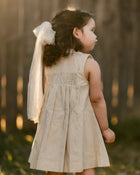 girl in a beige striped dress from the back