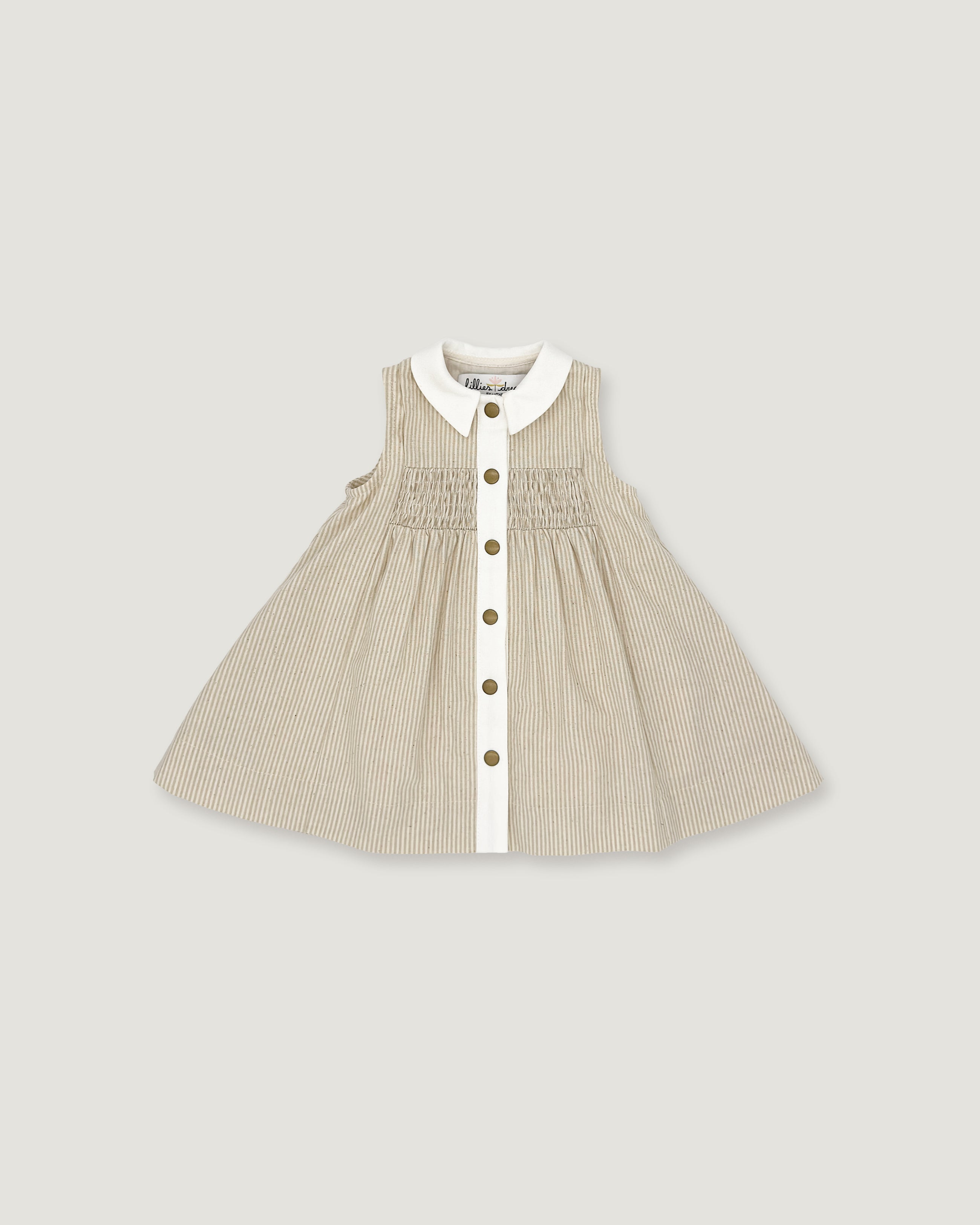 A sleeveless baby dress in beige and white vertical pinstripes, featuring a white Peter Pan collar, a smocked bodice, and a front button closure with gold-tone buttons, shown flat on a light gray background.