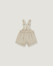 A pair of baby boy's cream-colored corduroy shorts with adjustable suspenders, laid flat against a light gray background.