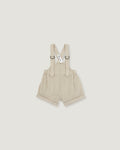 A pair of baby boy's beige corduroy suspenders shorts with adjustable shoulder straps and metal rings, shown flat on a light gray background.