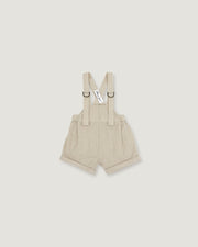 A pair of baby boy's beige corduroy suspenders shorts with adjustable shoulder straps and metal rings, shown flat on a light gray background.