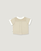 A short-sleeve baby top in beige with a checkered yoke and white sleeve cuffs, shown flat on a light gray background.
