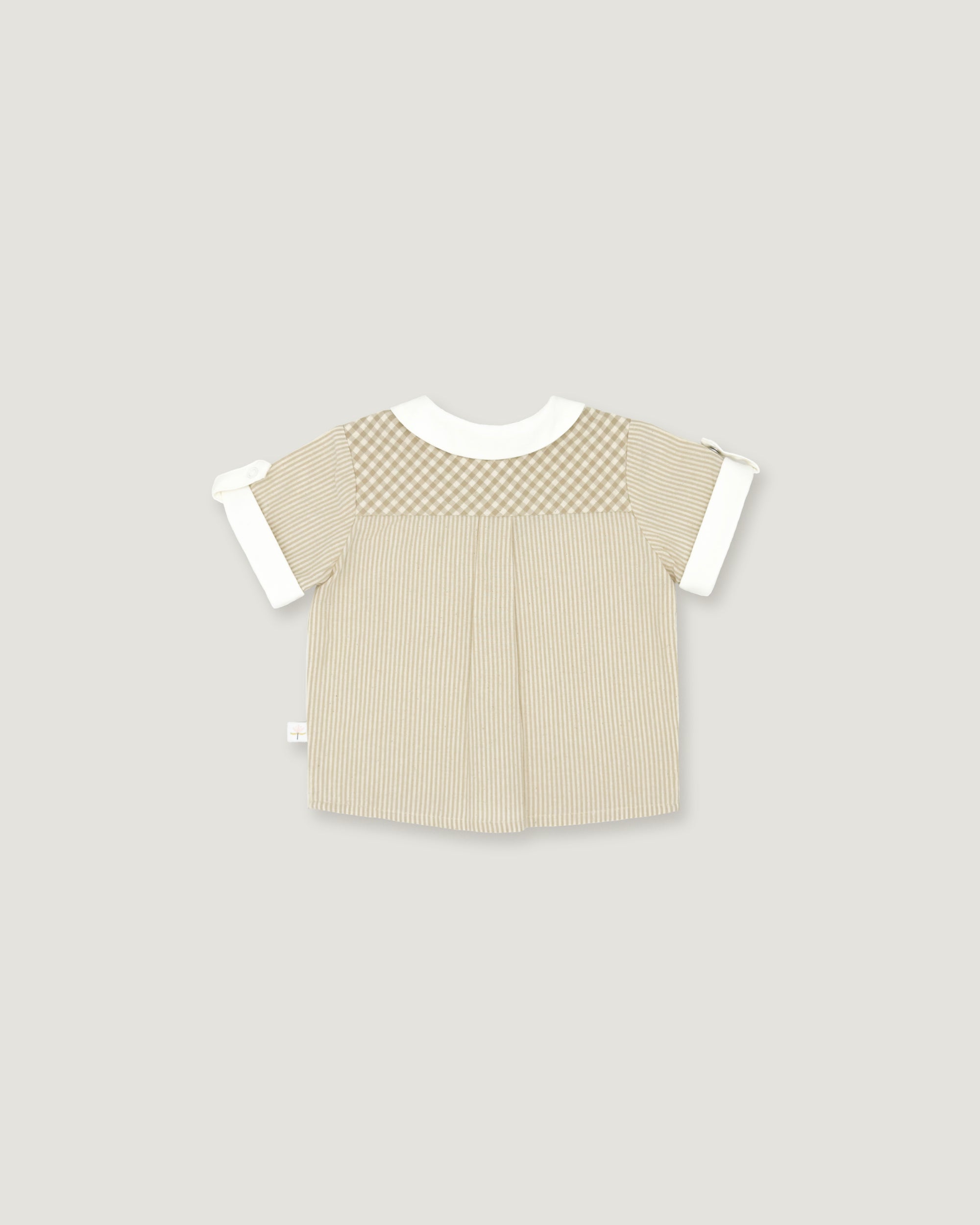 A short-sleeve baby top in beige with a checkered yoke and white sleeve cuffs, shown flat on a light gray background.