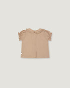 A light beige toddler girl's blouse with short ruffled sleeves and a ruffled collar, shown flat on a light gray background.