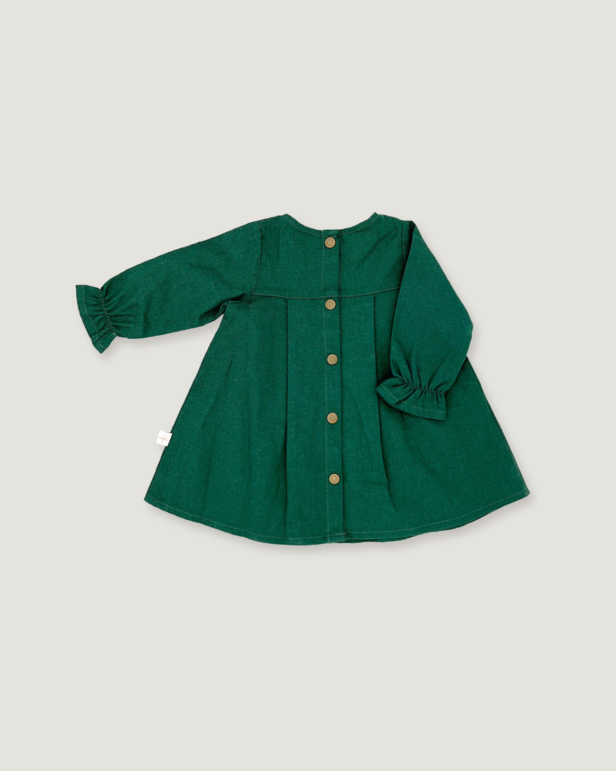 A dark green long-sleeve linen dress for toddlers, featuring a button-up front, gathered cuffs, and a flared silhouette, laid flat on a light gray background.