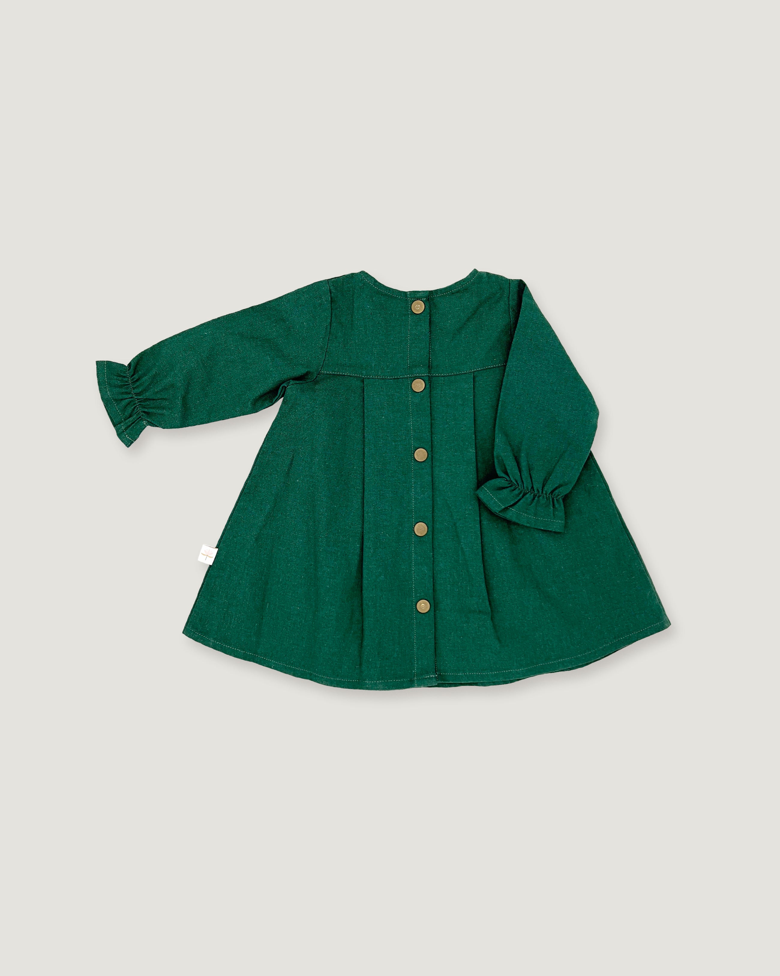 A dark green long-sleeve linen dress for toddlers, featuring a button-up front, gathered cuffs, and a flared silhouette, laid flat on a light gray background.