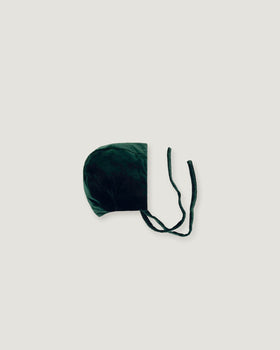 Evergreen velvet bonnet seen sideways on a white background