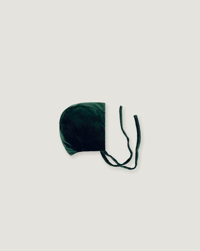 Evergreen velvet bonnet seen sideways on a white background