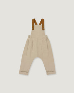 A pair of beige harem-style baby overalls with brown suspenders, shown flat against a light gray background.