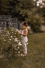Young girl in a field of flowers, holding a flower.
