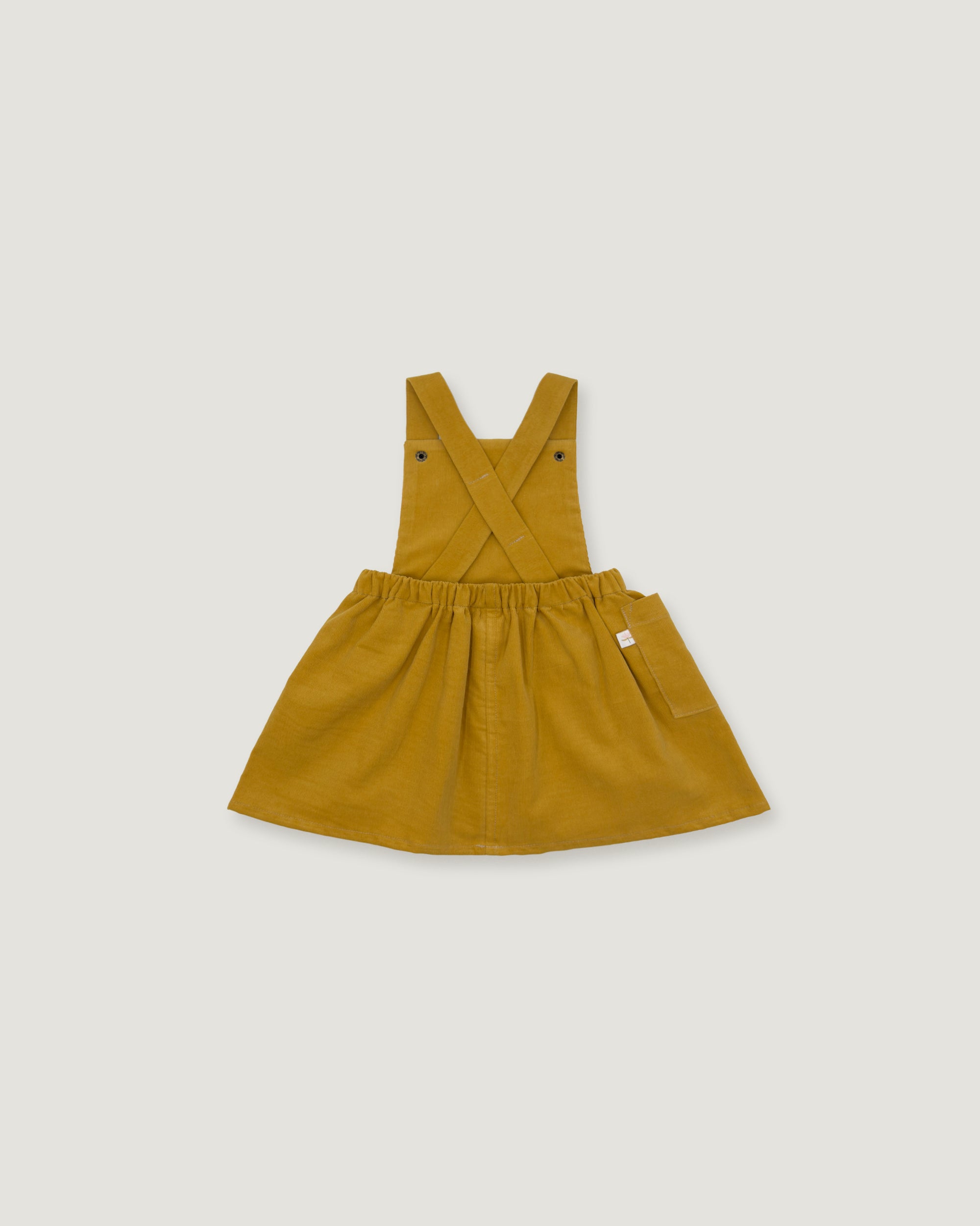 A mustard yellow children's overall dress with adjustable shoulder straps, a gathered waist, and a flared skirt, shown flat on a light gray background.