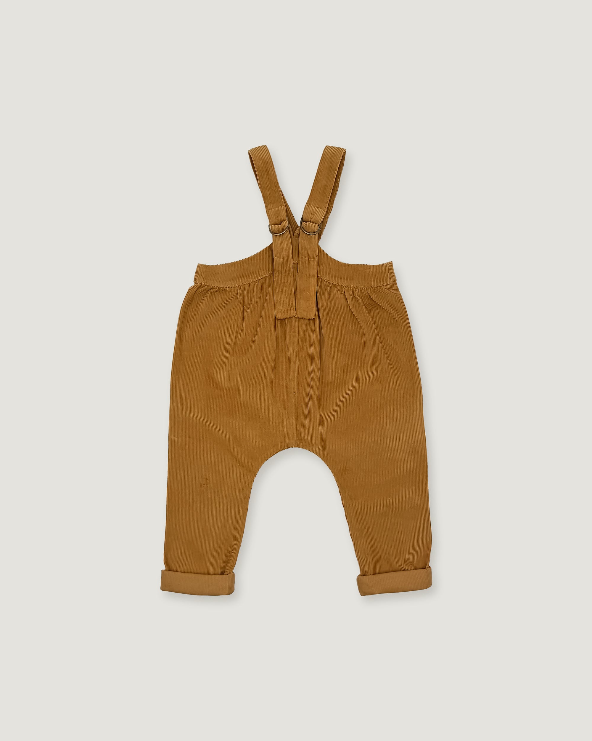 A pair of toddler bib pants in a warm camel brown corduroy fabric, featuring adjustable shoulder straps and rolled cuffs, shown flat on a light gray background.