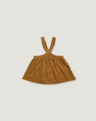 A toddler's brown linen suspender skirt with a gathered waist and wide straps, laid flat on a light gray background.