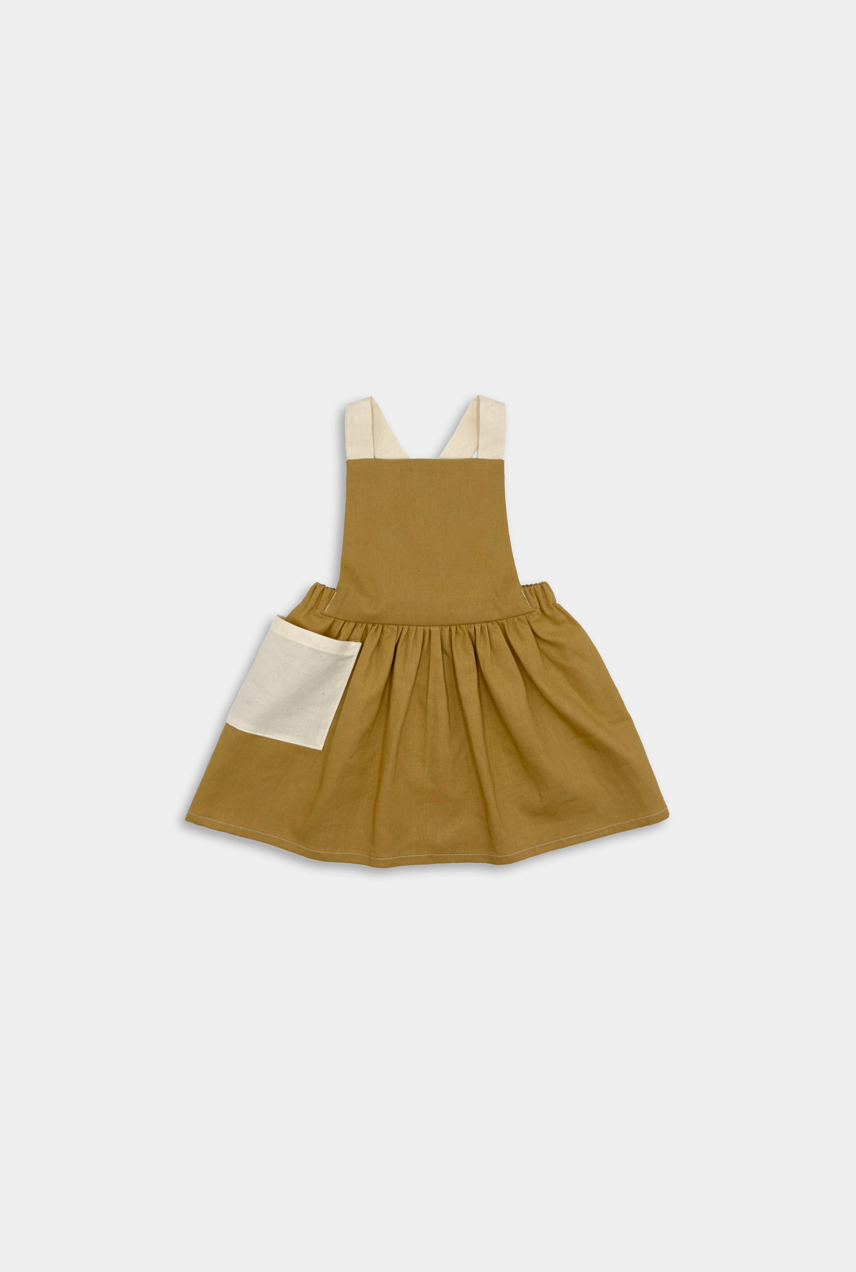 Front view of the Pinafore - Honey: A classic, handmade pinafore in a warm honey color, showcasing its timeless design with no top required, ideal for summer wear.