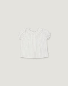 A white short-sleeve baby top with a ruffled Peter Pan collar and subtle vertical pleats, shown flat against a light gray background.