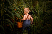 Back View of Model in Chambray Blue Long Overalls: A back view of the model wearing the Chambray Blue Linen Long Overalls, highlighting the adjustable straps and breathable fabric, designed for comfort and functionality.
