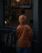 Back View with Bonnet: Back view of little boy in the Camel coat and bonnet, emphasizing the coat’s durability and timeless appeal for eco-conscious families.
