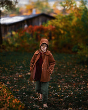 Ezra, a 5-year-old boy model, is captured mid-stride in the Camel coat and matching Camel Corduroy Bonnet, embodying playful energy and style, perfect for active children.
