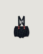 A pair of baby boy's plaid bib shorts with suspenders, featuring a dark green and black checkered pattern, red button accents, and a white brand tag on the suspenders, shown against a solid light gray background.