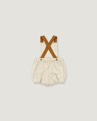 A baby romper with cream-colored fabric and brown suspenders, shown flat on a light gray background.