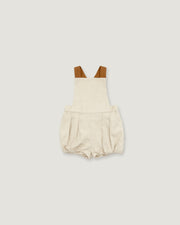A baby romper in a textured cream linen-like fabric, featuring brown shoulder straps, displayed flat against a solid light gray background.