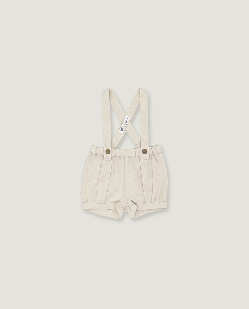A pair of baby boy's cream-colored linen suspenders shorts with adjustable shoulder straps and metal snap buttons, shown flat on a light gray background.