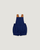 A pair of navy blue baby shorts with adjustable brown shoulder straps, laid flat against a light gray background.
