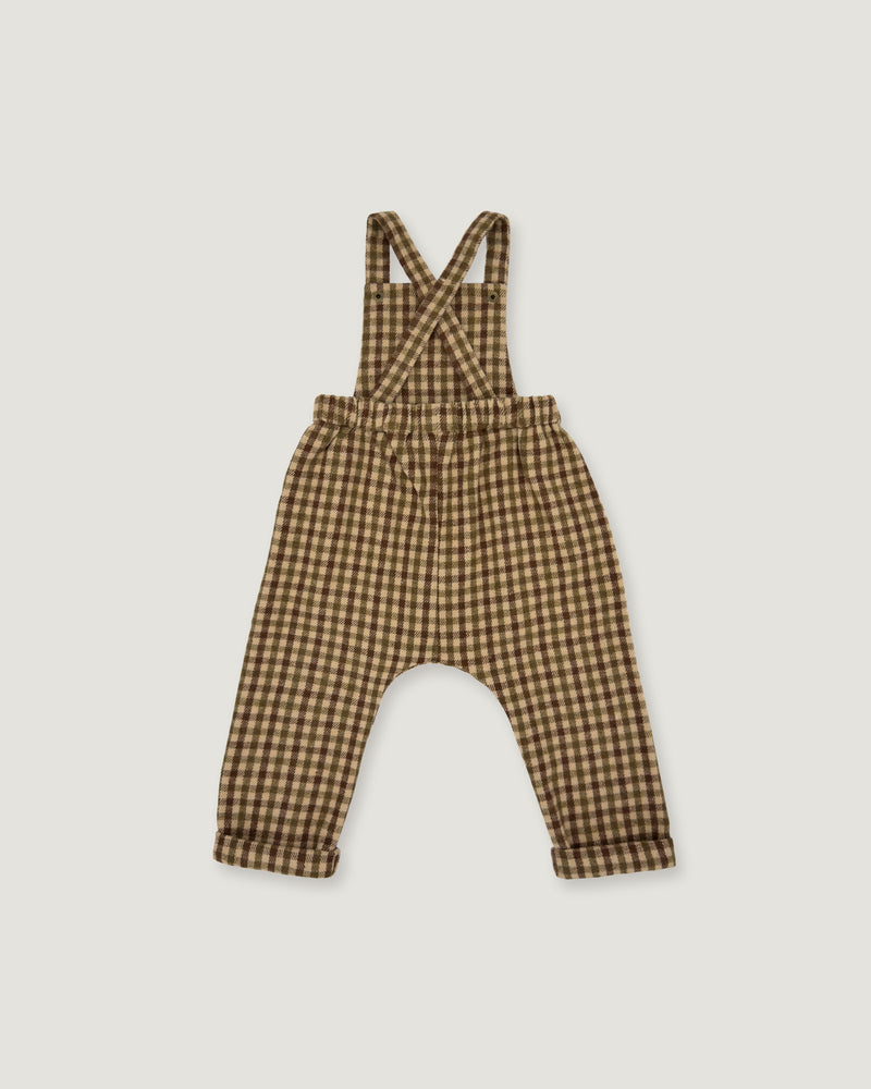A baby romper with suspenders in a brown and beige gingham check pattern, laid flat on a light gray background.