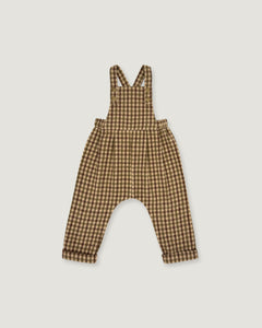 A baby romper with brown and beige gingham check print, featuring shoulder straps and a wide leg design, shown flat on a light gray background.