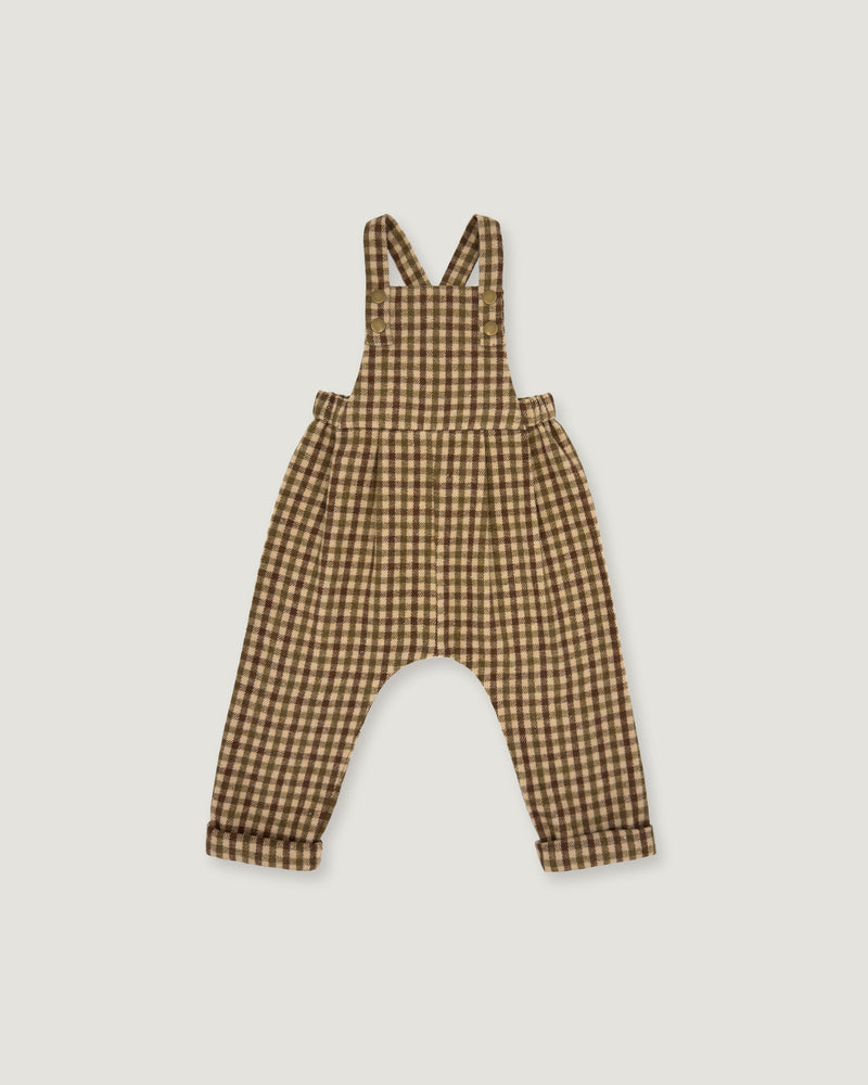 A baby romper with brown and beige gingham check print, featuring shoulder straps and a wide leg design, shown flat on a light gray background.