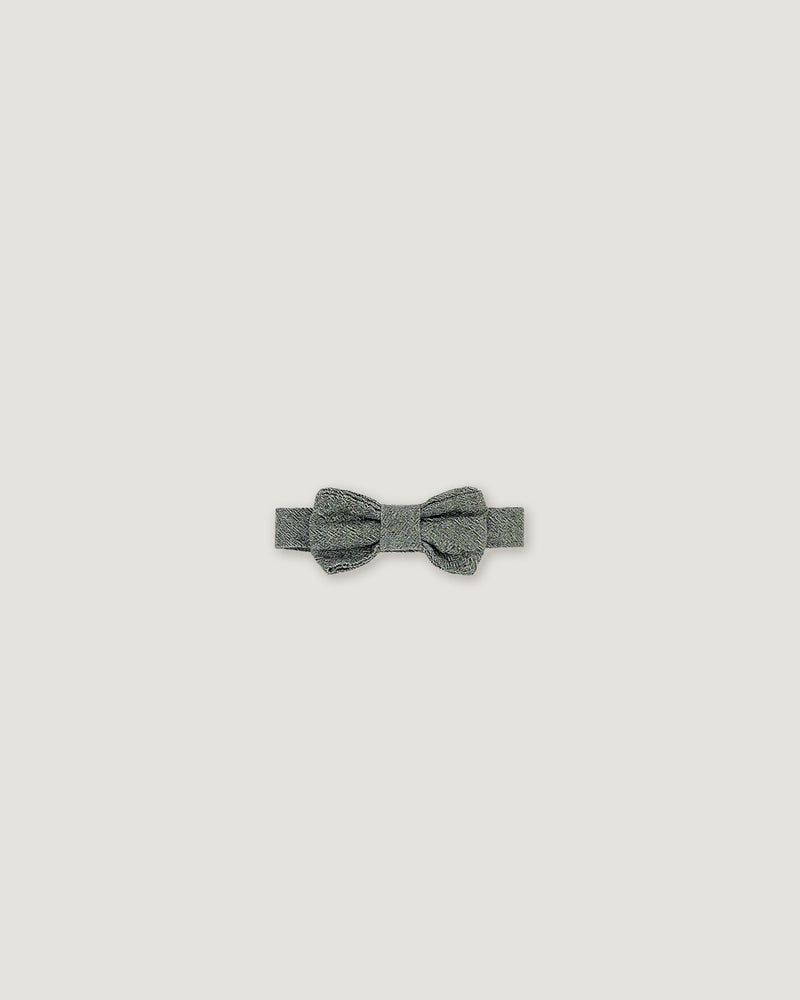 A small gray bow tie with a textured, glittery finish, centered on a solid light gray background.