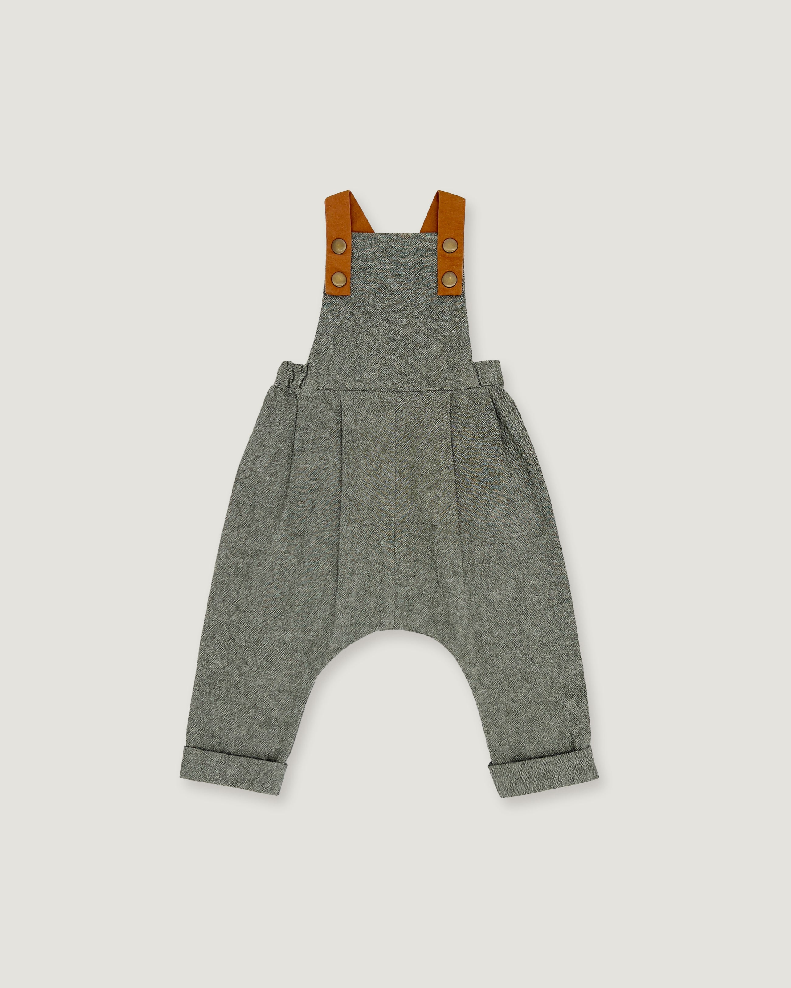 A pair of baby overall pants in heather gray wool, featuring brown leather shoulder straps with snap buttons, shown flat on a light gray background.