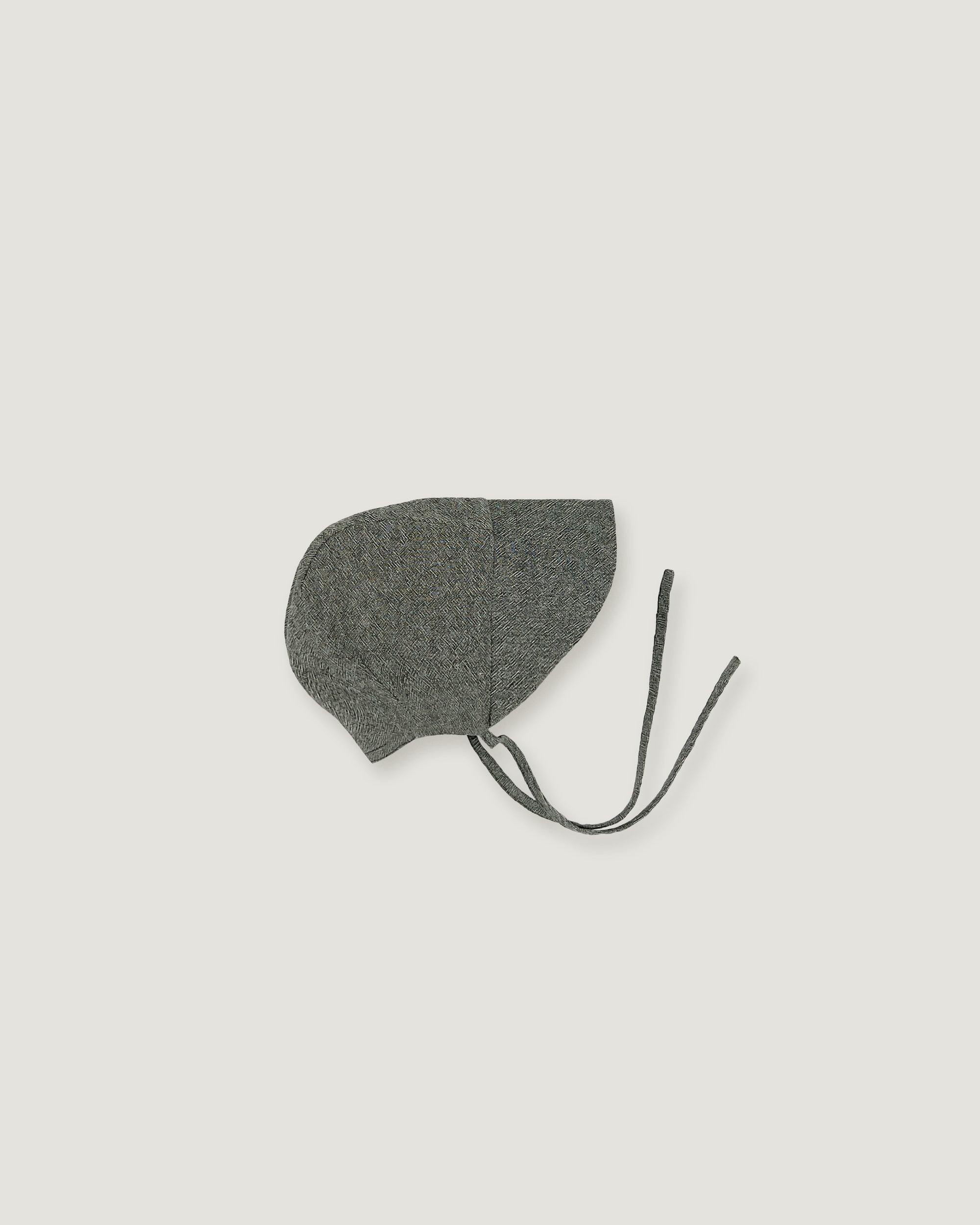 A green linen bonnet with a long visor  on a white background