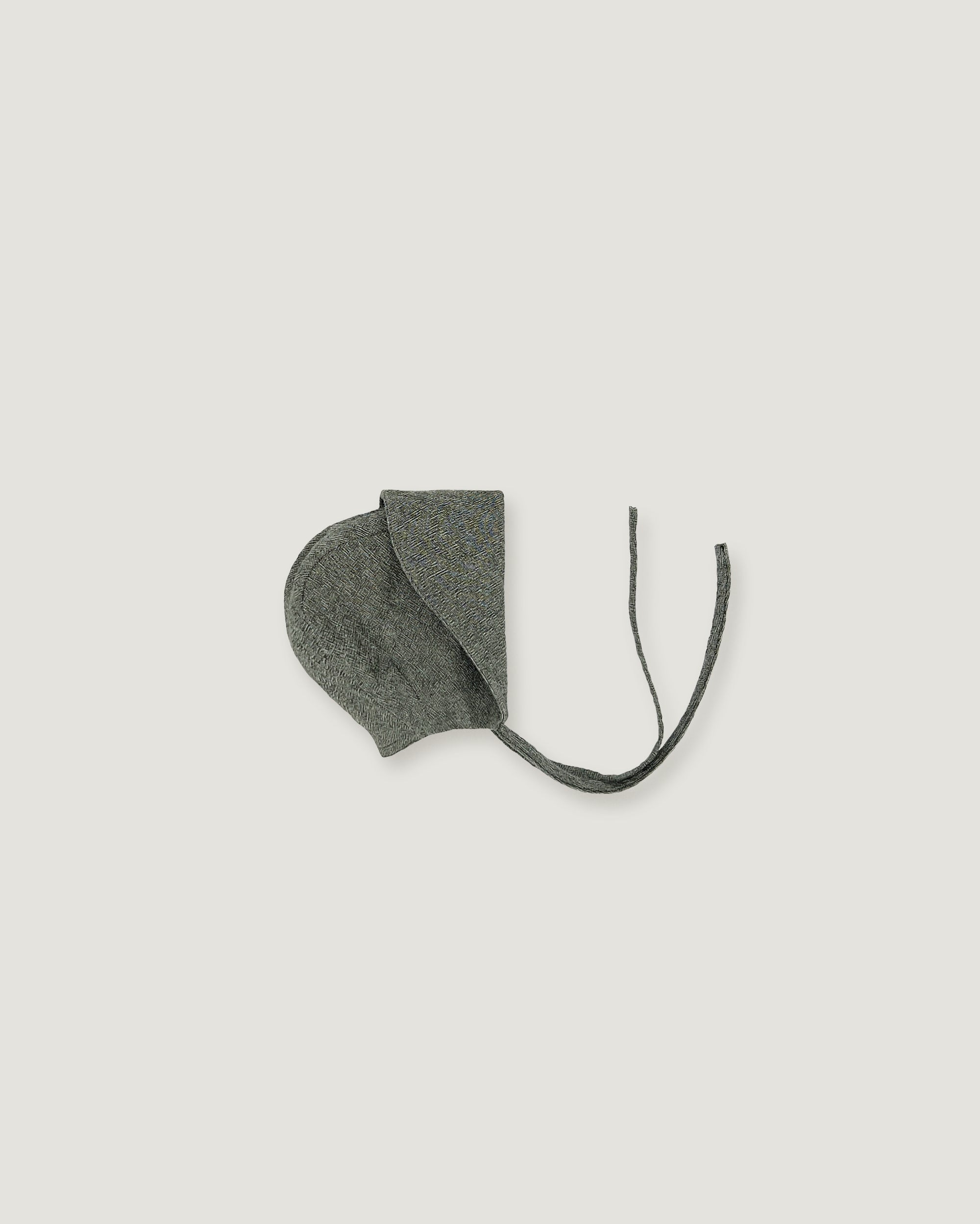 A green linen bonnet with a long visor rolled up  on a white background